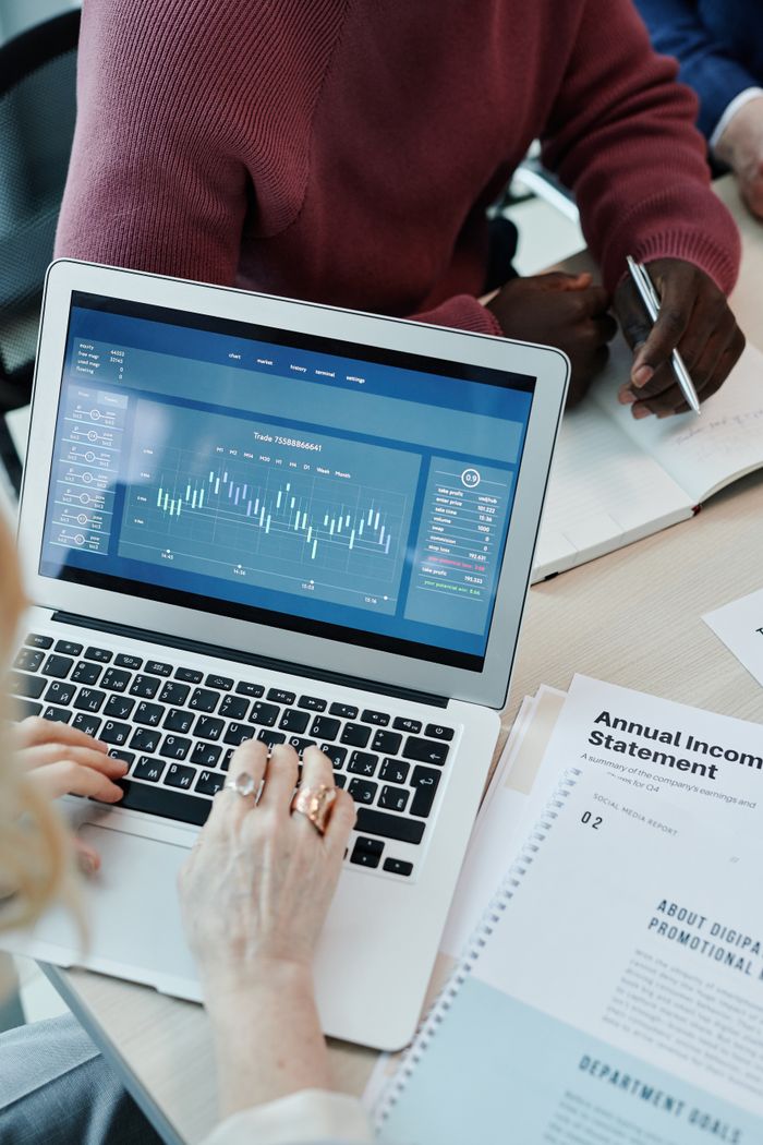 The Art of Drawing Readers In: Your attractive post title goes here Collaborative business meeting with data analysis on laptop and financial papers.